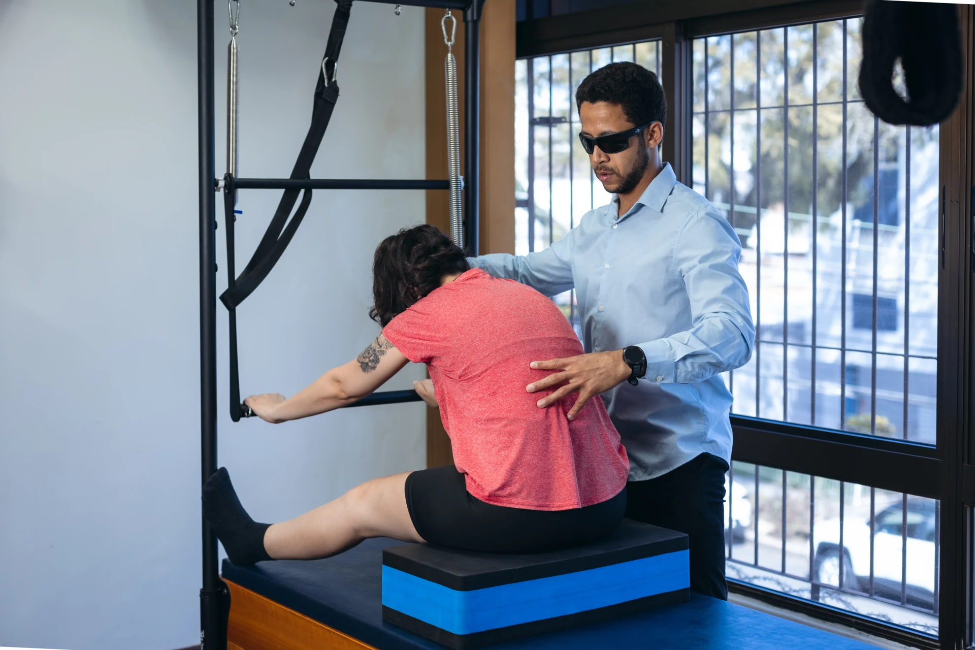 Paciente realizando exercício de pilates clínico com acompanhamento do fisioterapeuta para reabilitação e melhora da postura